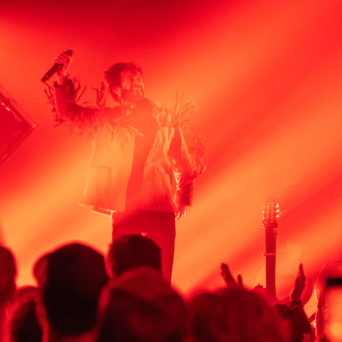 a man in a white shirt and a microphone in front of a red light