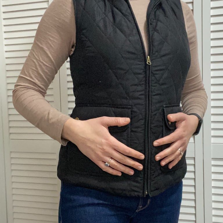 Woman holding stomach addressing hormone issues and fibroids