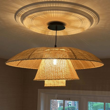 Moderne hanglamp in natuurlijke tinten en een decoratieve plafondrozet.