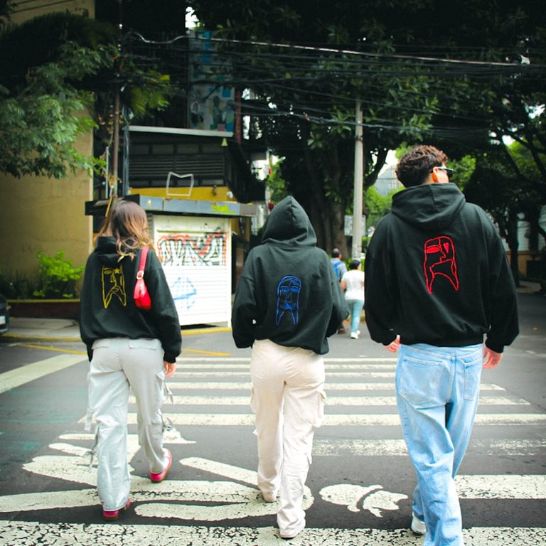 three people walking across a crosswalk in a city