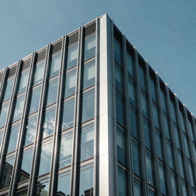 Close-up of architectural glass and metal detailing on a modern corporate facade under a clear blue sky.