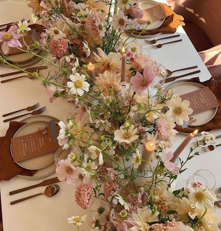 Mesa elegante con guirnalda floral pastel.