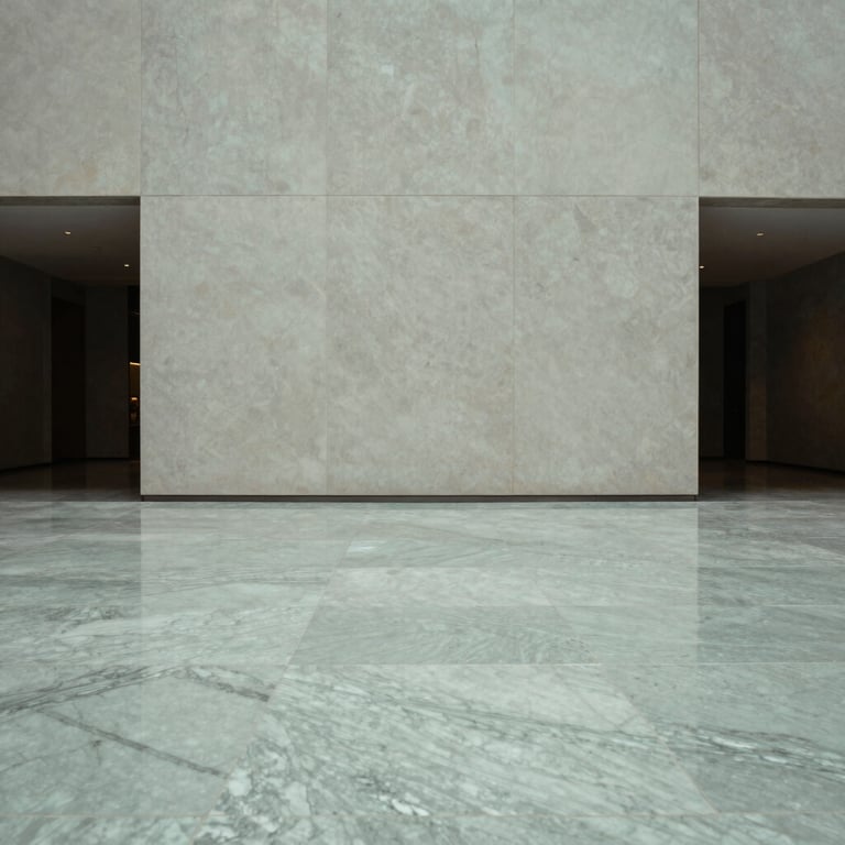 Interior shot of a minimalist building lobby with pale grey-green marble flooring.