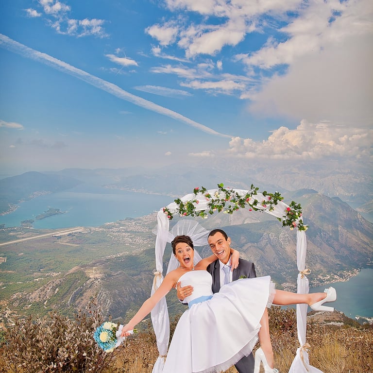 Groom lifting the bride, standing on high mountain above Tivat and Kotor