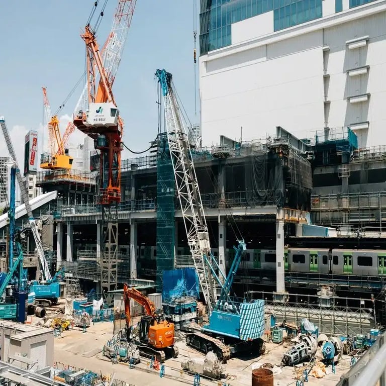 Heavy machinery and cranes working on a large scale site development and infrastructure project