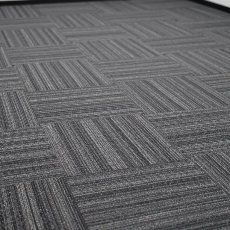 A close-up of premium office carpet tiles in shades of #1C2833 and grey, laid in a professional pattern.