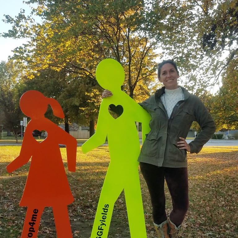 Mandy posing with a sculpture of two walkers