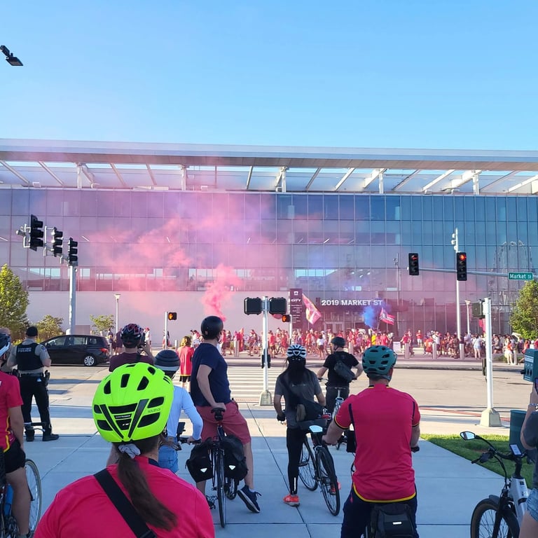 Large shot of a biking event with pink smoke in the air