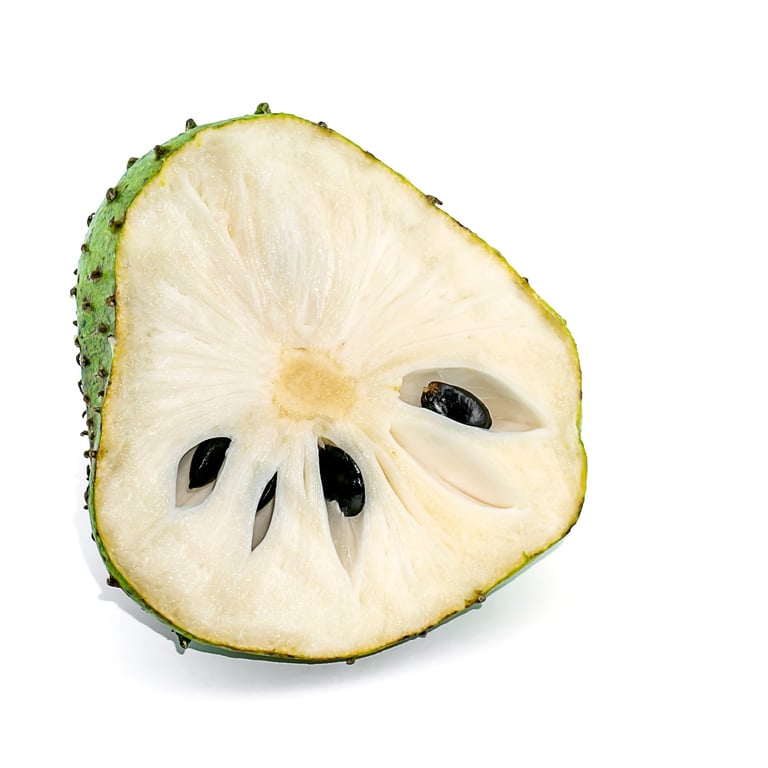Fresh guanábana fruit cut in half showing white pulp and seeds