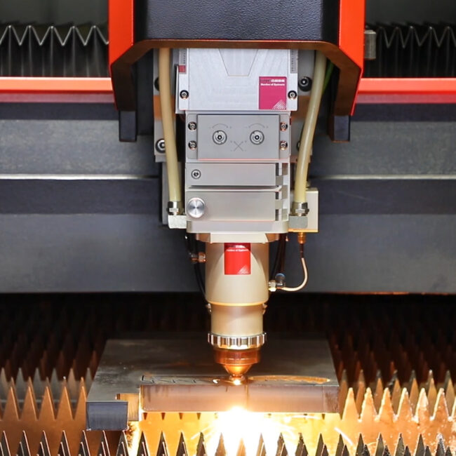 Industrial CNC fiber laser cutting machine precision processing a metal plate with sparks.