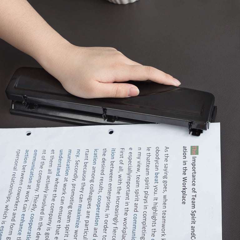 Black Amazon Basics 3-hole paper punch with 10-sheet capacity and easy-clean chip tray