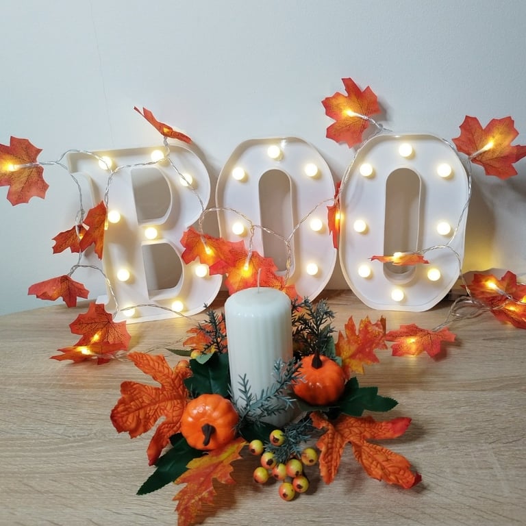Thanksgiving candle wreath with orange maple leaves, pumpkins, and berries