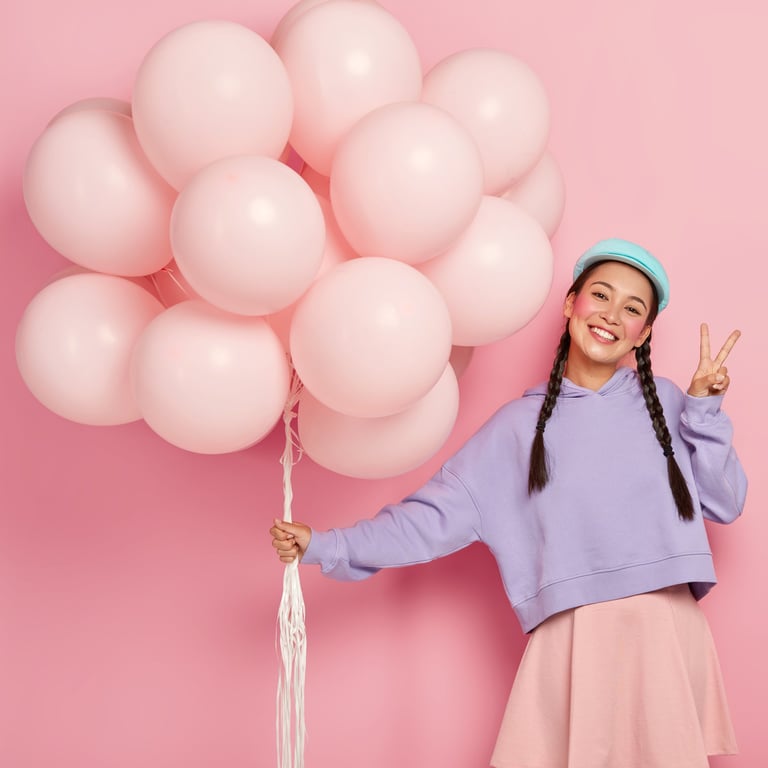 a woman in a blue sweater holding a bunch of balloons
