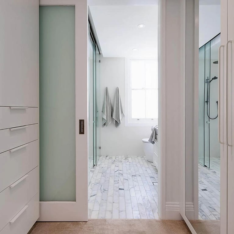 Custom walk-in robe with bespoke millwork, seamlessly integrated into a restored Victorian bedroom