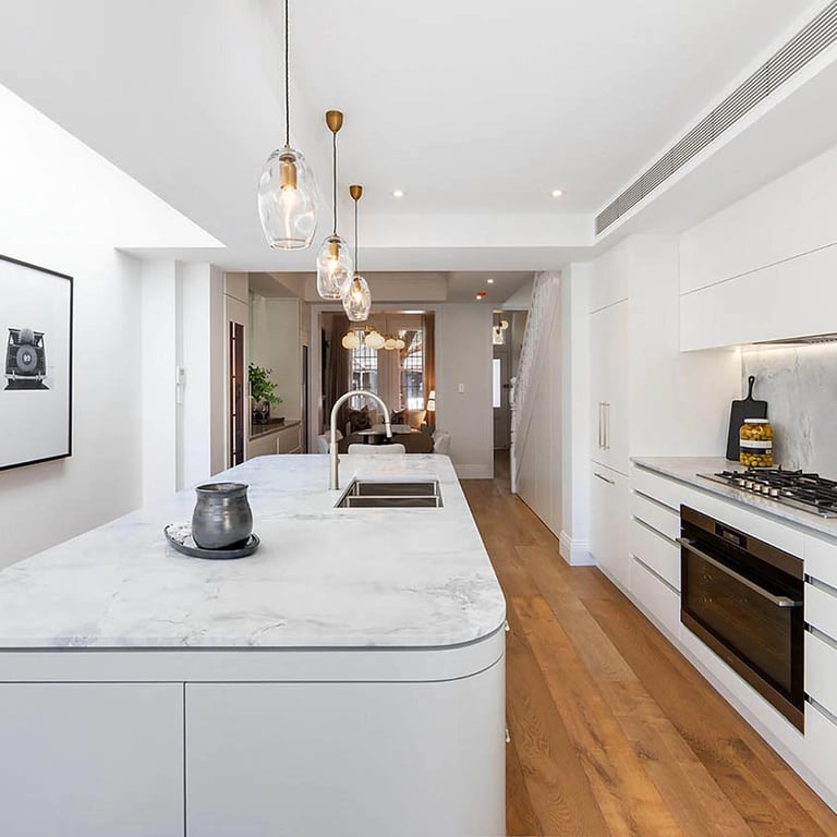 Heritage-inspired kitchen with Calacatta marble countertops, flush polyurethane cabinetry, and gunmetal fixtures.