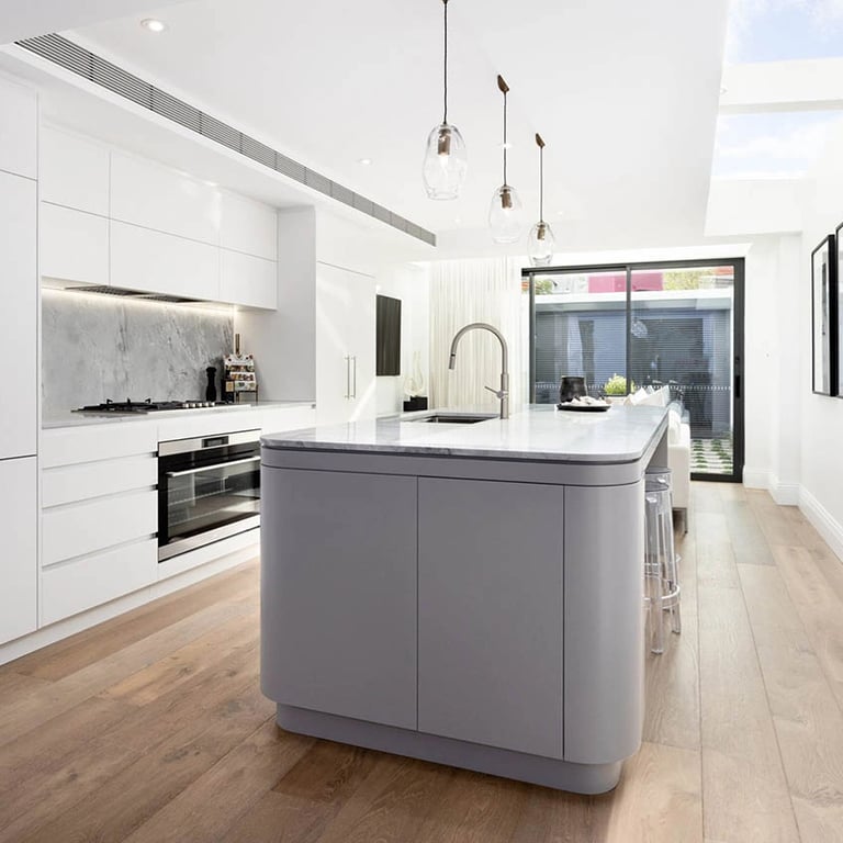 Sleek kitchen with fluid stone island, ergonomic design, and integrated smart appliances in Victorian terrace