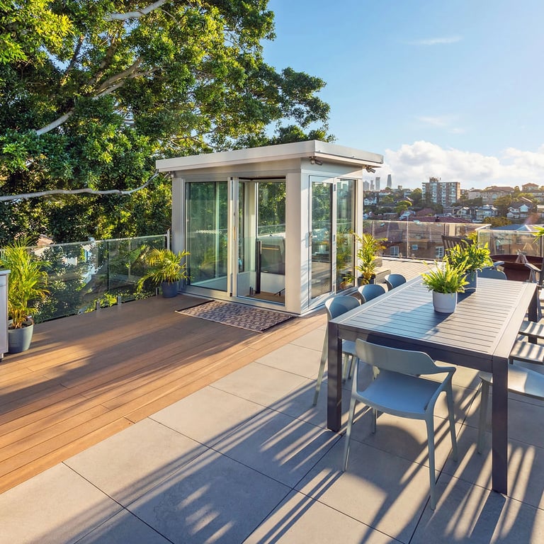Green rooftop terrace in Mosman, with an outdoor dinign table, floating decking