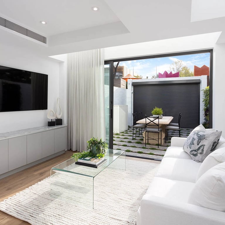 Light-filled entertainment space with biophilic design elements, blending original architecture with modern comforts