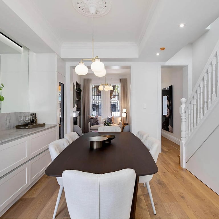 Elegant dining space with bespoke quartz cabinetry, integrated regrigeration, and mirrored light enhancement