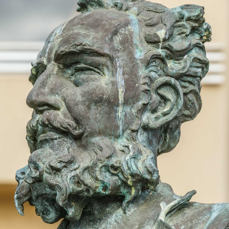 Bronze statue bust of a bearded man with curly hair and a mustache. Antonio Cano Cervantes