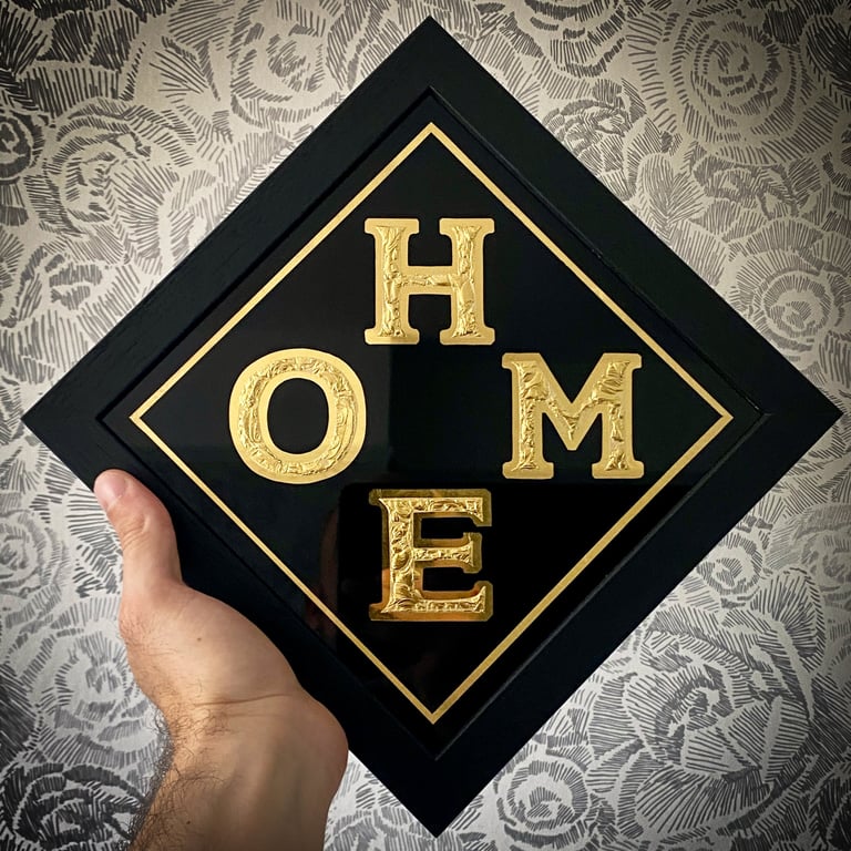 chipped glass lettering sign with gold leaf, black background and frame