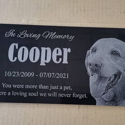 Laser-engraved granite plaque in memory of a dog named Cooper with the text 'You were more than just