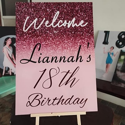 Welcome sign for Liannah's 18th birthday on a pink and glittery Sintra board.