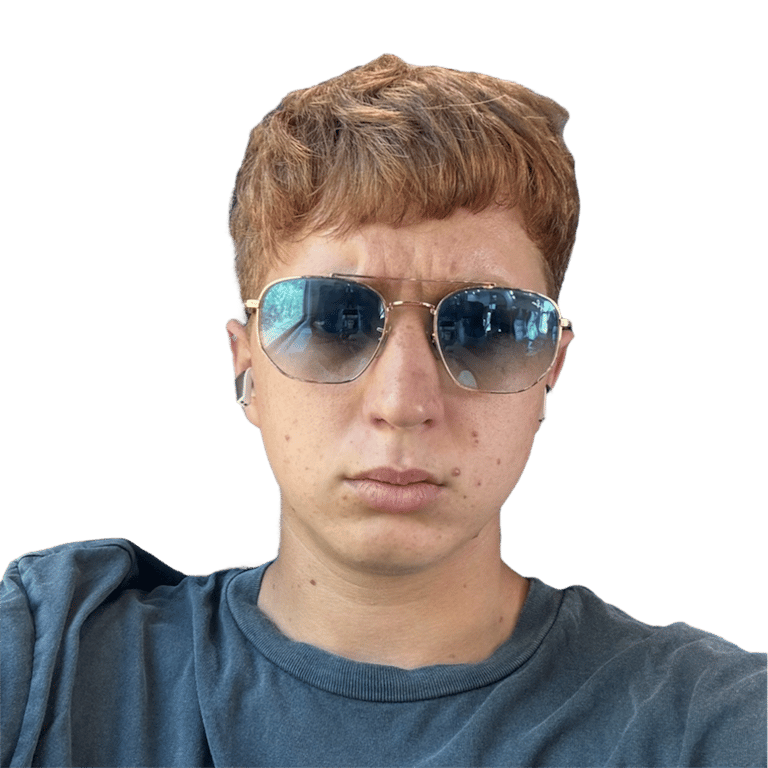 Young person with short strawberry blonde hair wearing gold-rimmed aviator sunglasses.