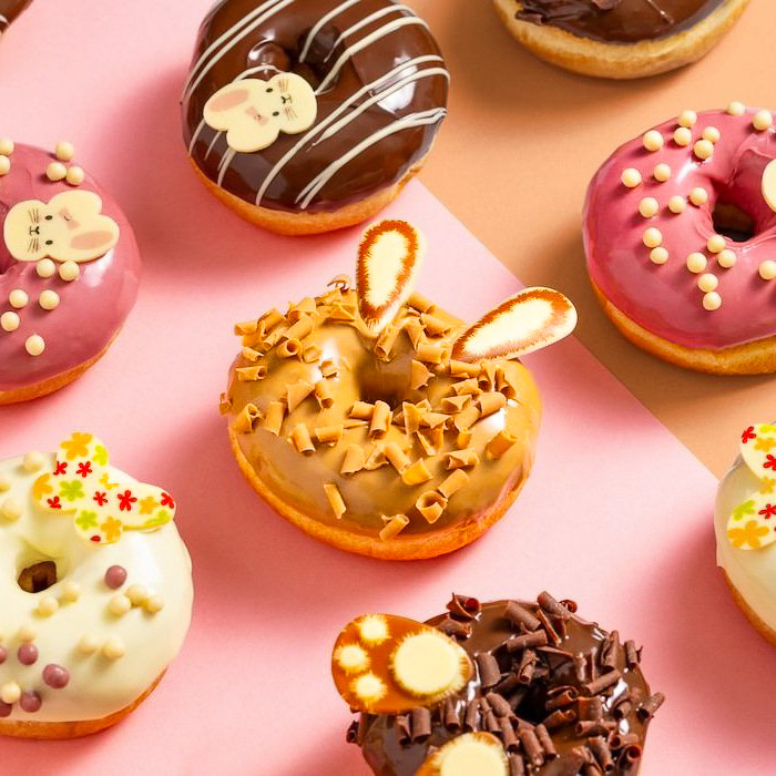 a variety of donuts and donuts on a pink background
