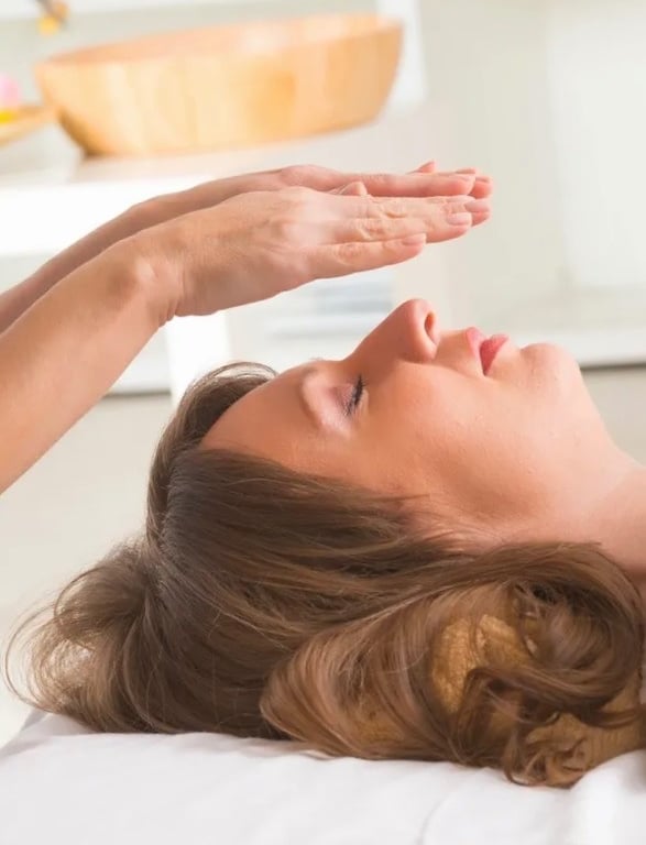 Practicing Reiki by hovering hands over a woman's face