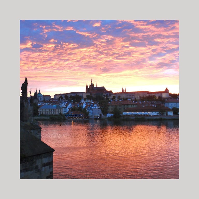 Strahlender, oranger Sonnenuntergang über der Prager Burg, als Logo für Mystiker Stadtbummel