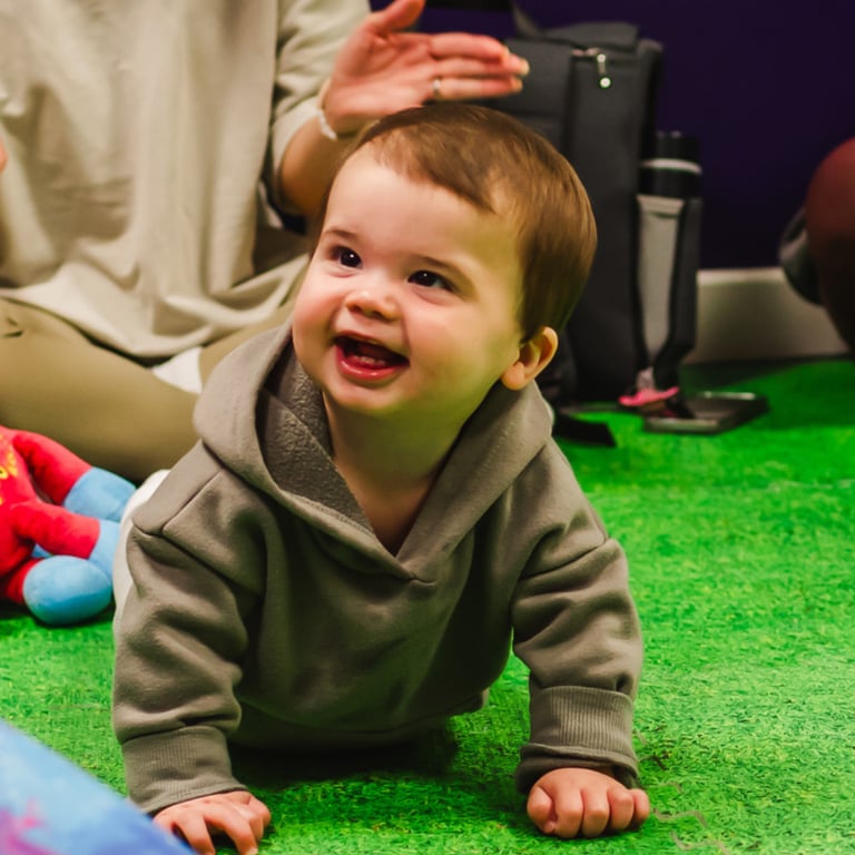 Mini moo baby boy smiling, crawling and playing in class.