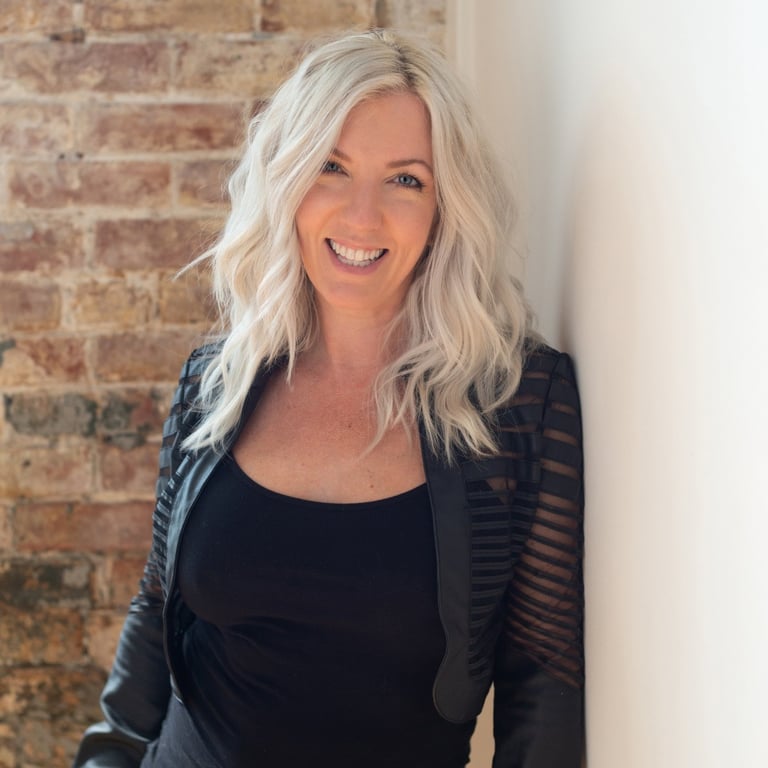 Headshot of artist and photographer Tanya Smith of Sweet Ruby Moon on brick wall