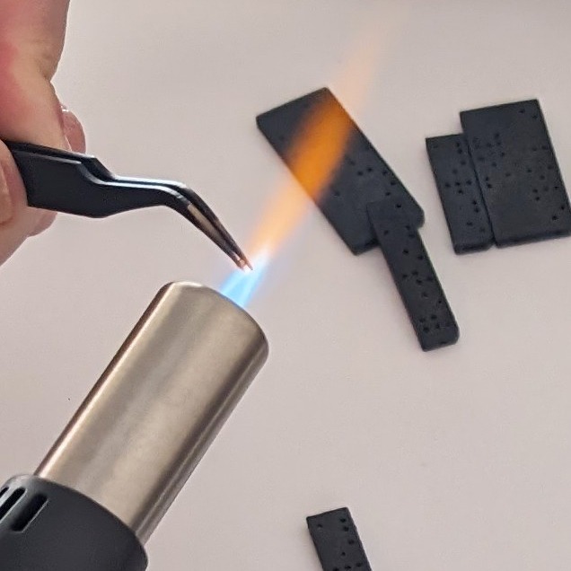 Thermosoudure avec une pince chauffée au chalumeau, utilisé pour fixer des billes d'acier