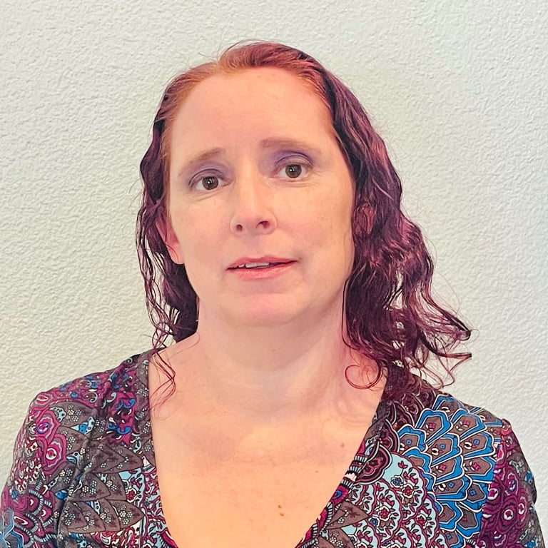a woman with red hair and a patterned shirt
