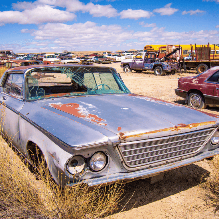 a car parked in a field with a lot of junk