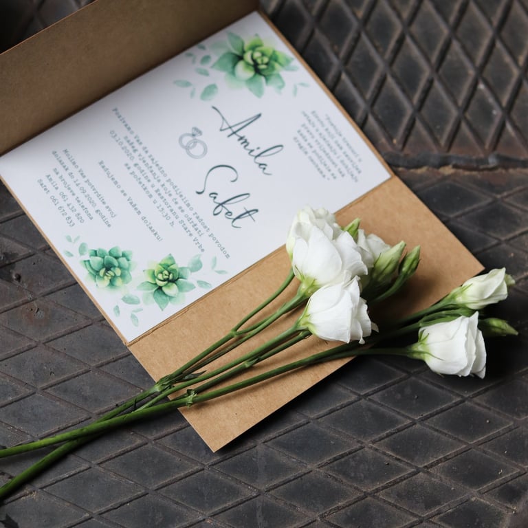 a wedding invitation with flowers on a table