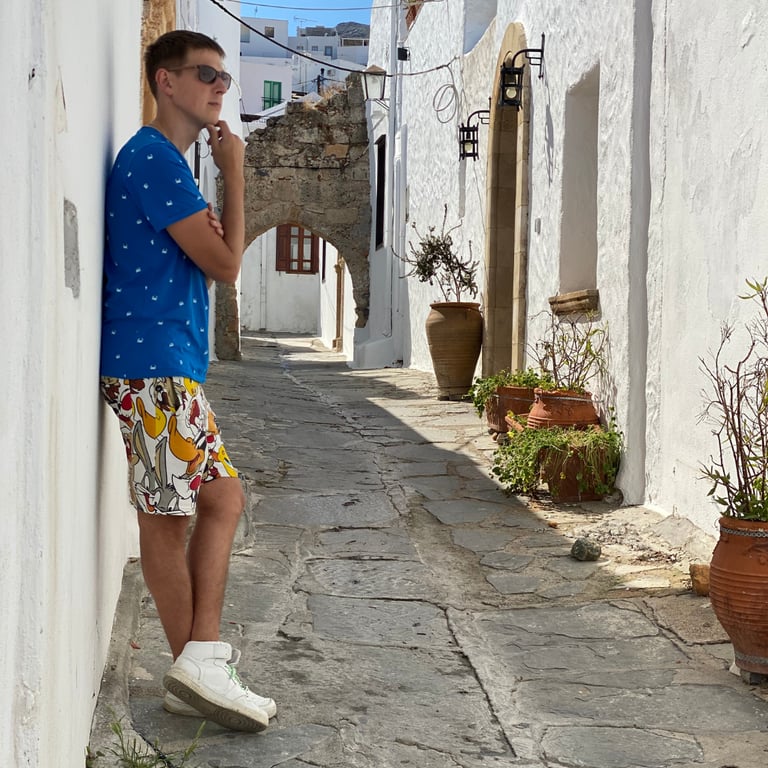 a man standing on a sidewalk in a narrow alley
