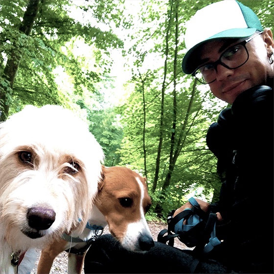 Foto von einem Mann mit zwei Hunden im Wald