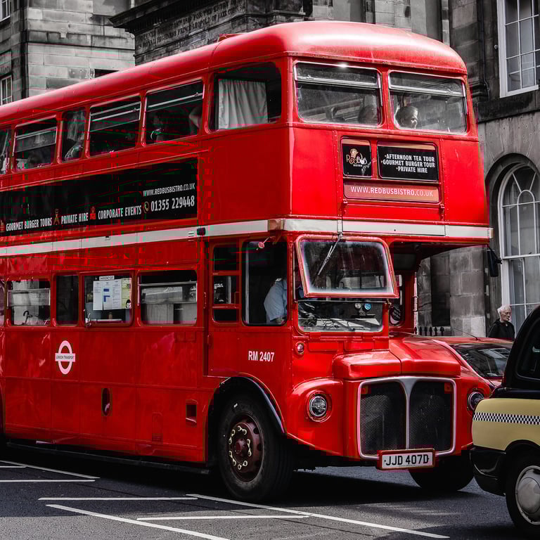 Un emblématique bus londonien rouge, en plein cœur d'Édimbourg, ajoute une touche vintage à l'ambiance écossaise urbaine.