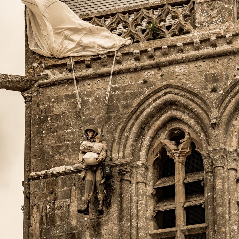 Réplique de John Steele, parachutiste américain, suspendue au clocher de l'église de Sainte-Mère-Église, symbole d'héroïsme.