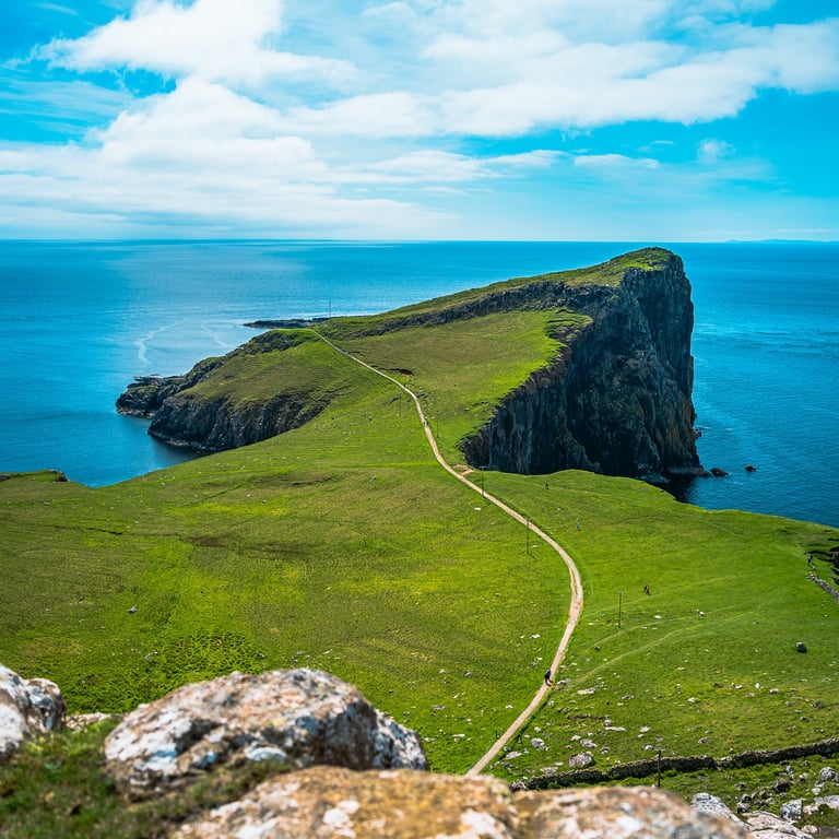 Le sentier de Neist Point serpente à travers les falaises verdoyantes, offrant une vue spectaculaire sur l'océan Atlantique.