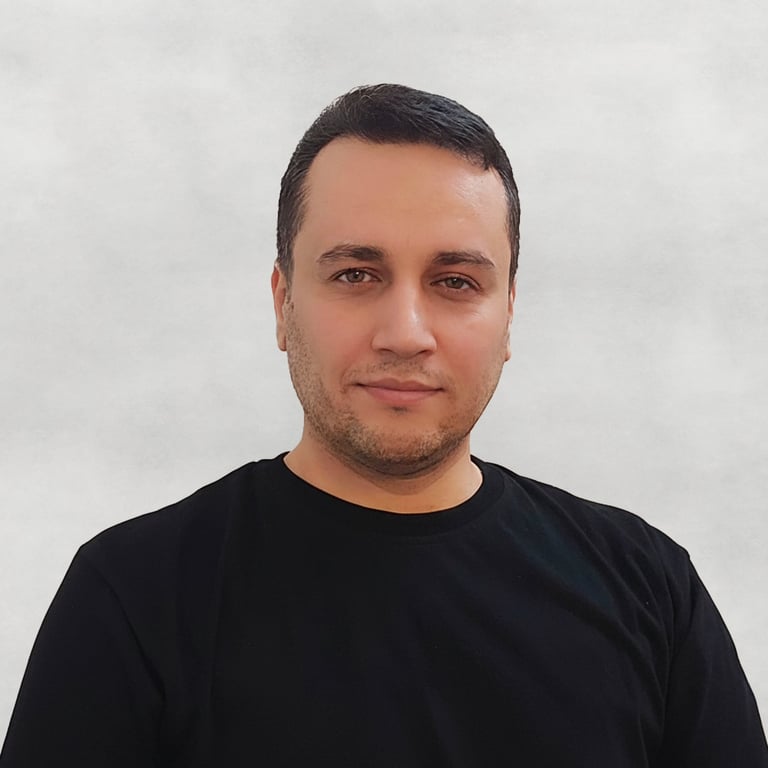 Portrait of a VISUALISE team member, black T-shirt, with a plain neutral background.