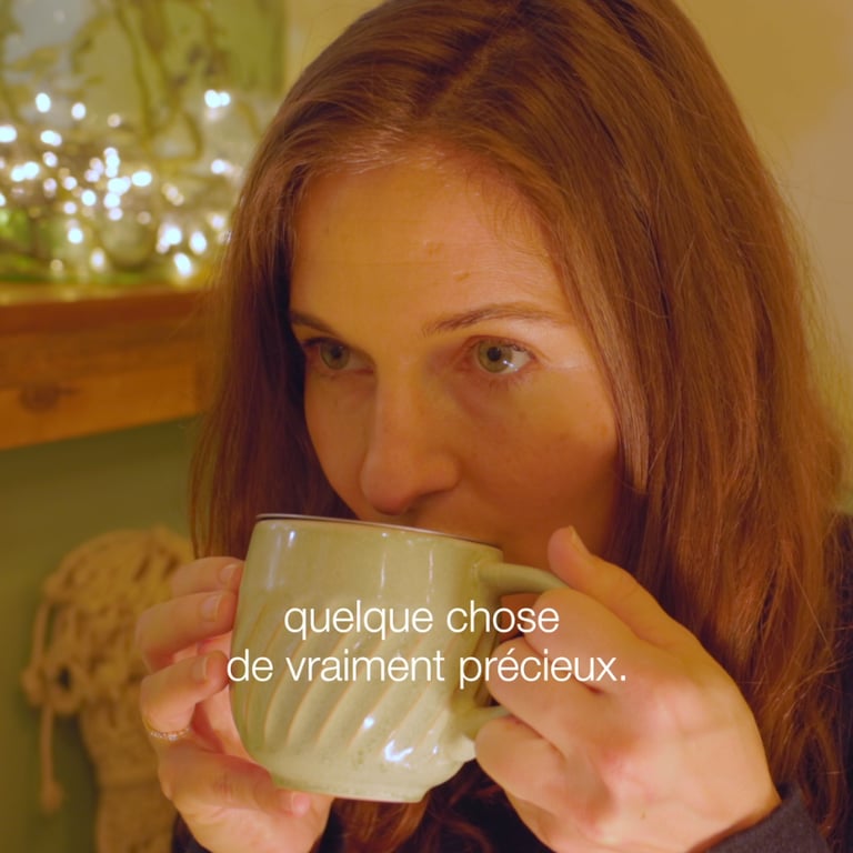 a woman is drinking a cup of tea