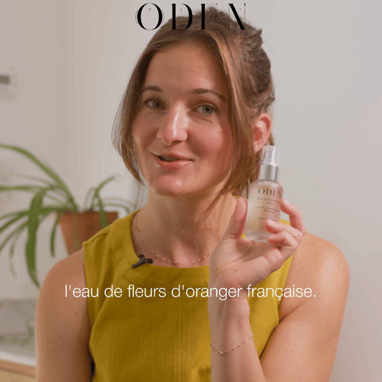 a woman in a yellow dress holding a bottle of cosmetic