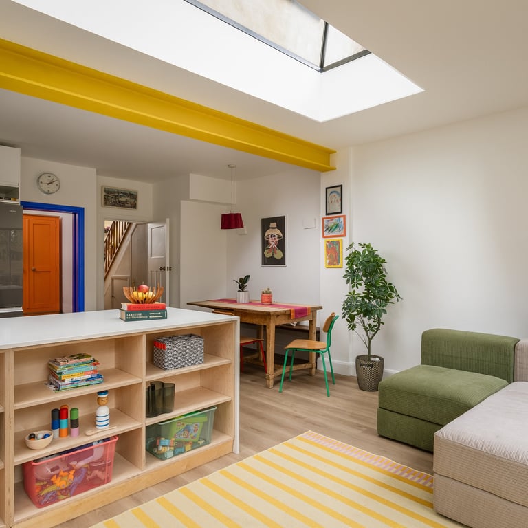an open plan colourful living room with storage for kids toys, modular sofa and dining table