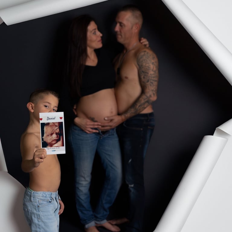 niño sujeta ecografia mientras que sus papas se miran en   segundo plano  v 