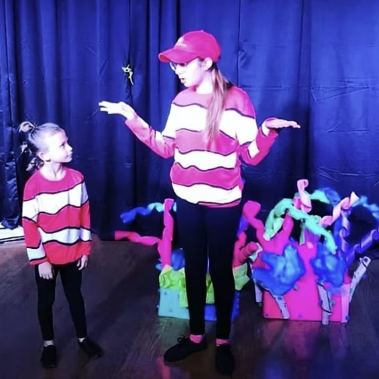 Kid actors in a musical written by a teen playwright presented at the KidWorks Festival in colorful costumes.