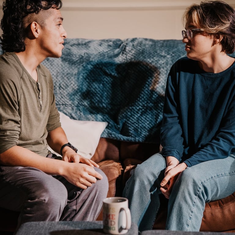two actors sitting on a couch portraying best friends in anew original play by Trent Clifford.