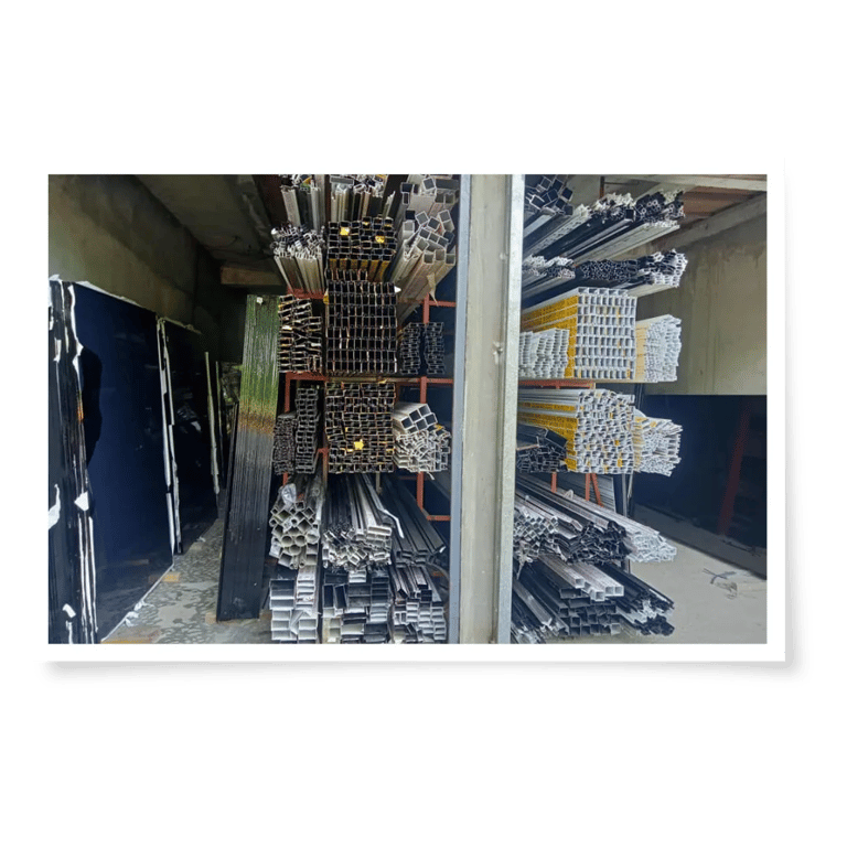 A warehouse filled with neatly stacked metal profiles and sheets, showcasing various shapes and sizes for construction use.